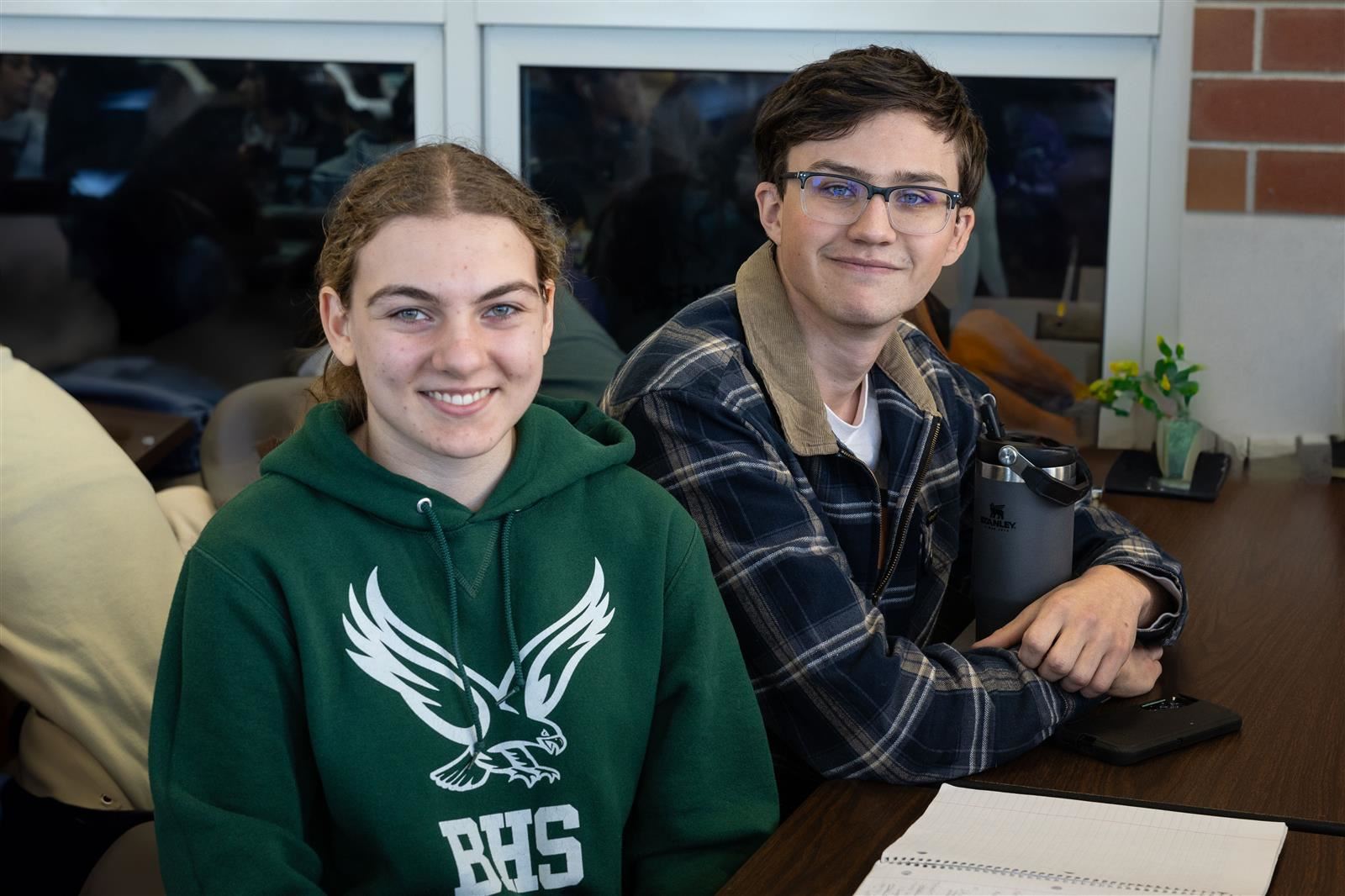 Two students at lunch smile at the camera