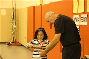 Teacher showing student how to use heart monitor 