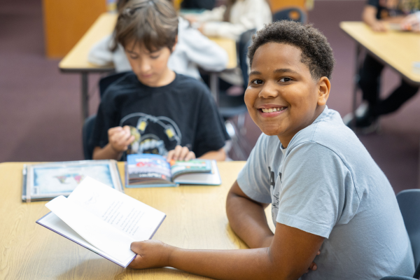  A boy holds up a book